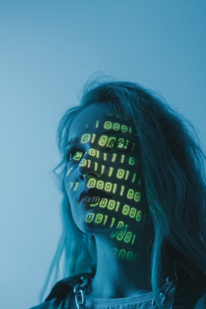 A woman with binary code lights projected on her face, symbolizing technology.